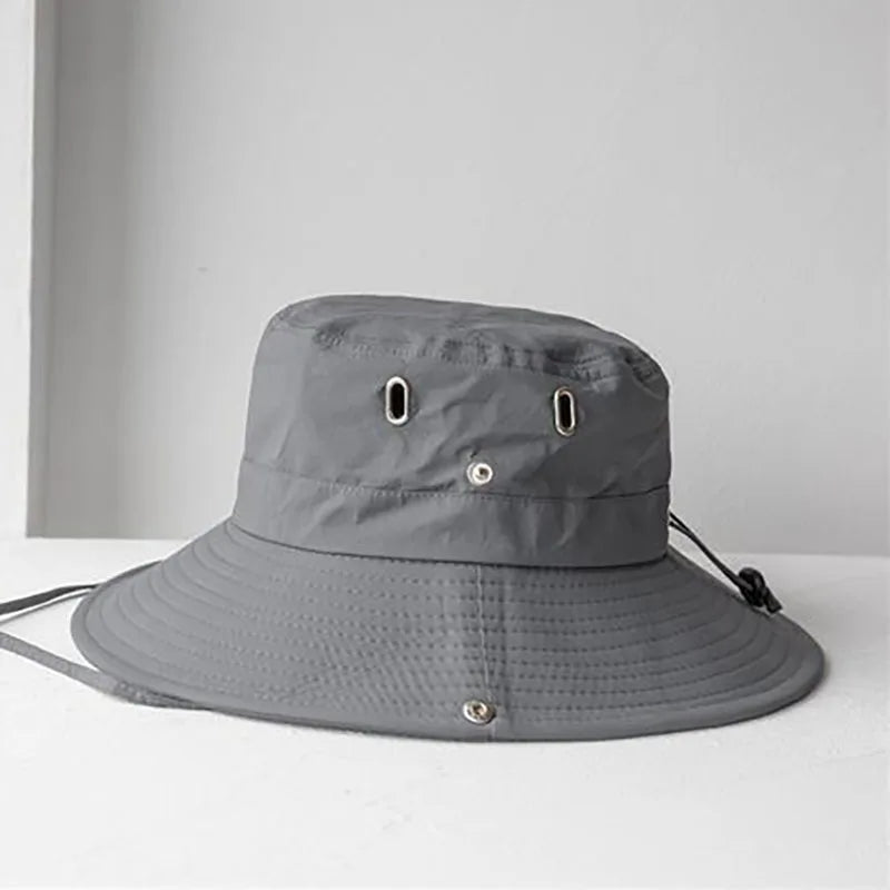 Gray bucket hat on a white surface with a gray curtain background