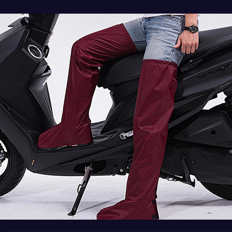 A person wearing burgundy over-the-knee rain boots while sitting on a black scooter, with light blue jeans and a wristwatch visible.