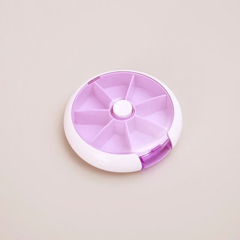A round, multi-compartment pill organizer container with a translucent lavender purple lid and a white base, shown on a solid light beige background.