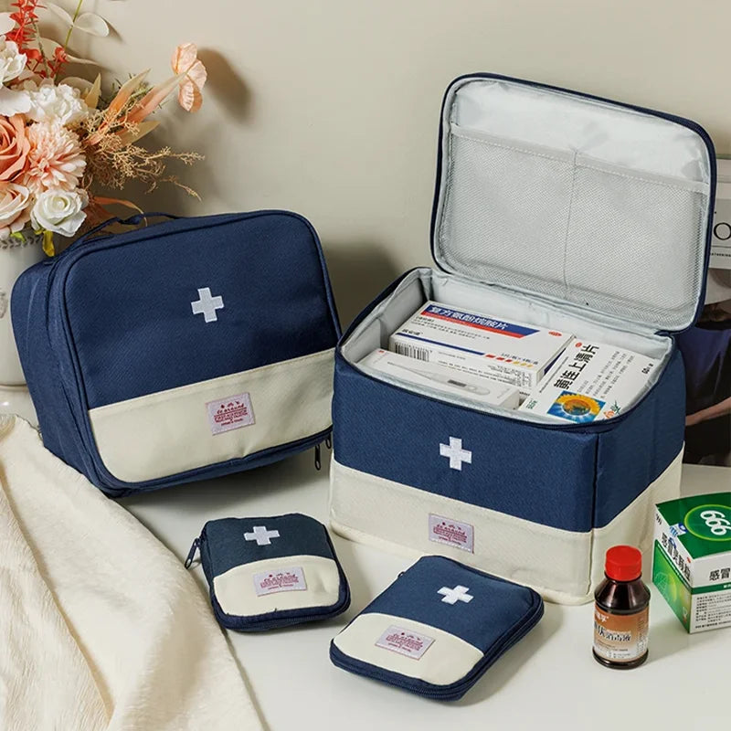 Set of blue and beige first aid kits with medical supplies on a table.