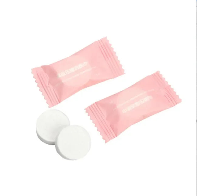Two pink packets and two white round objects on a white background