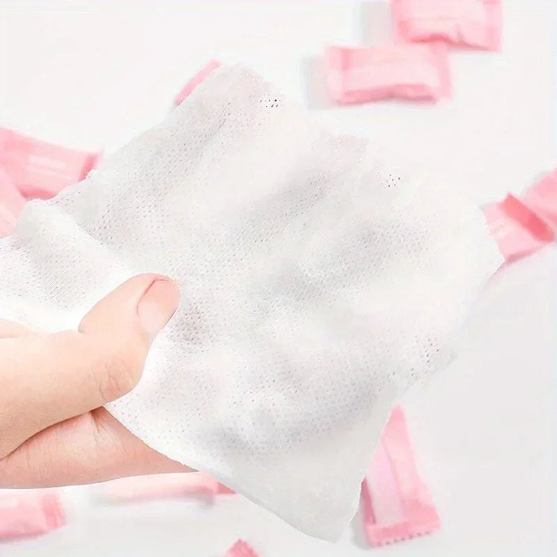 White towel with pink edges held by a hand against a white background