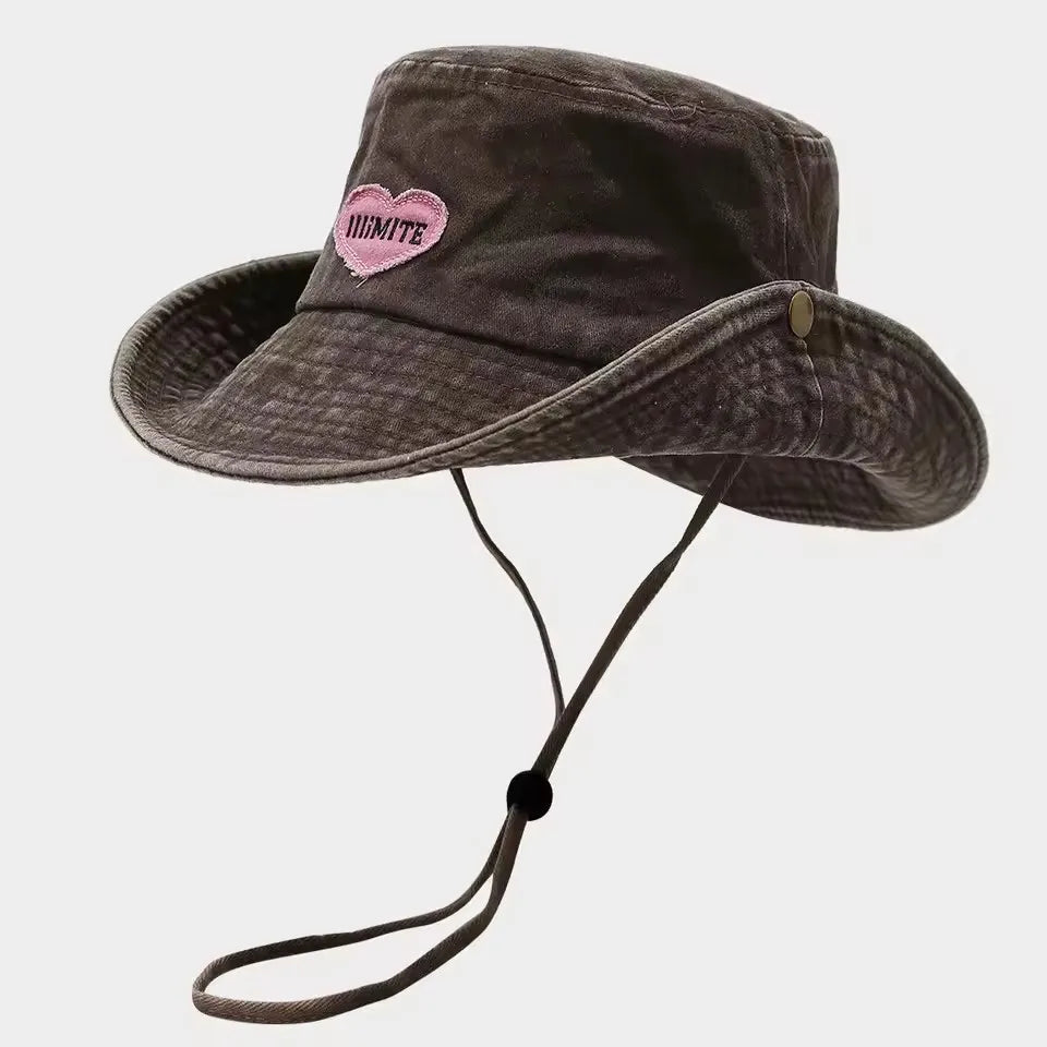 Brown bucket hat with a pink heart logo on a light gray background