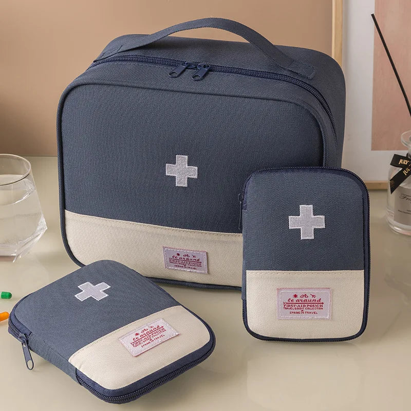 Set of blue and beige first aid kits with cross symbols on a light surface.