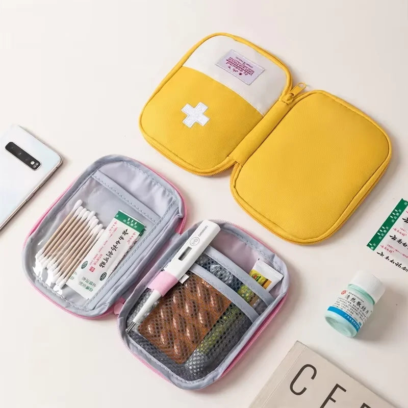 Yellow first aid kit with open compartments containing medical supplies on a white background.
