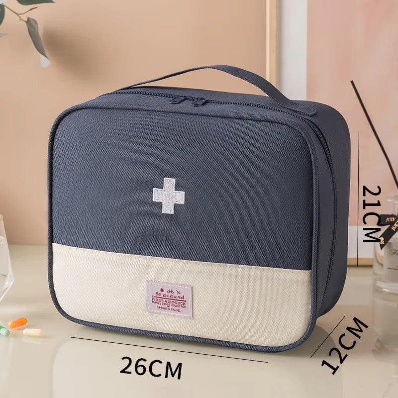 Blue and beige first aid kit with dimensions displayed on a light surface.