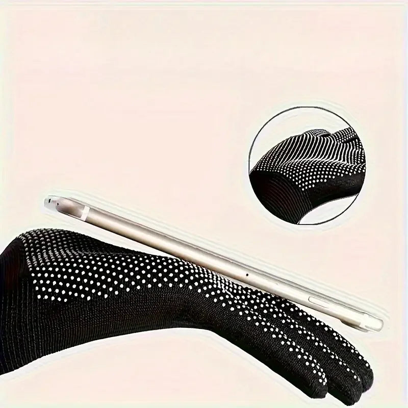 Black touch screen gloves with white dots on a light pink background