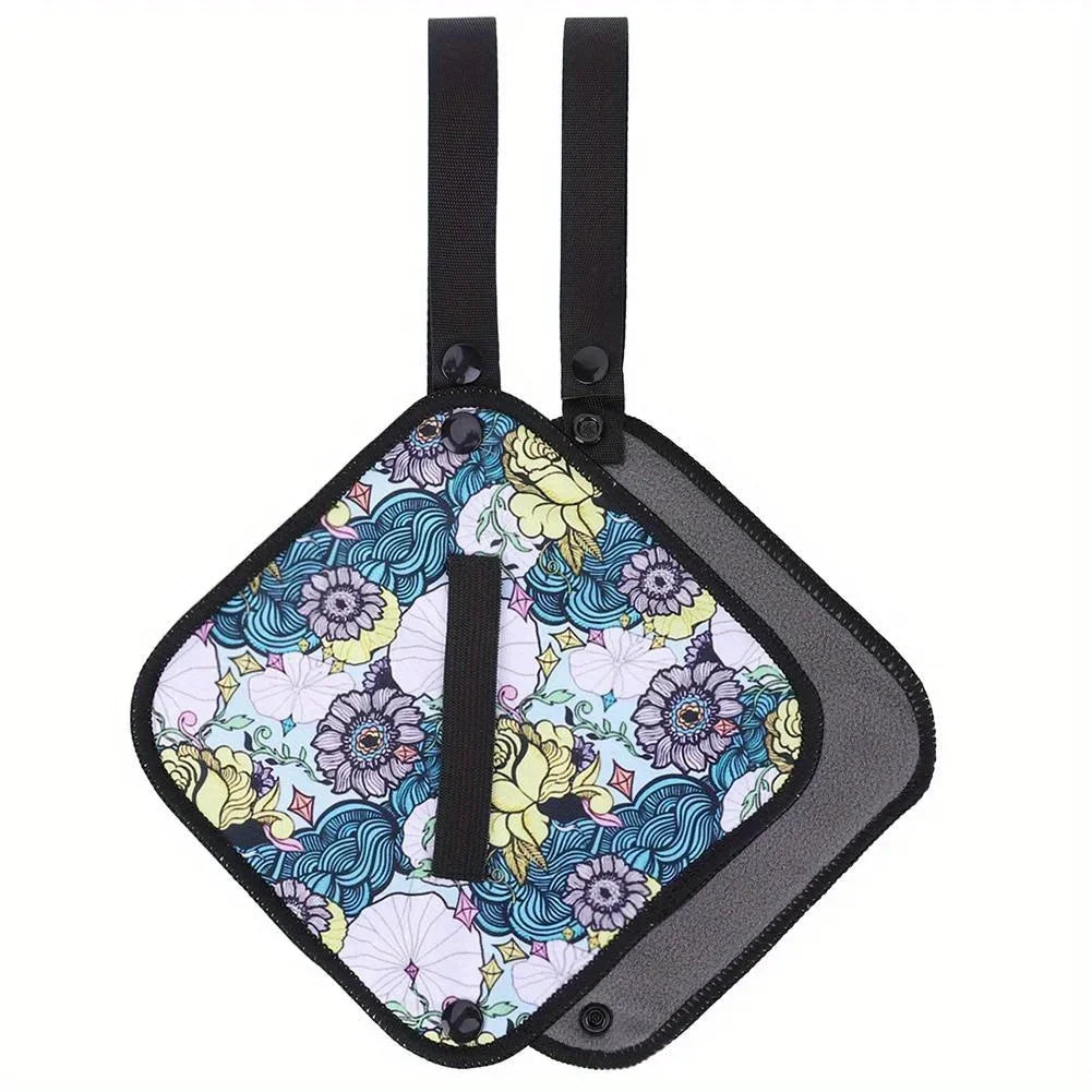 Pair of floral-patterned pot holders with black straps on a white background