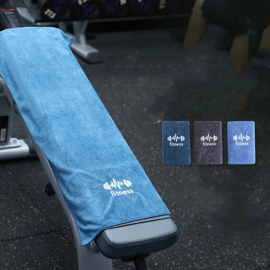 Blue fitness towel draped over a gym bench with additional towels in the background.