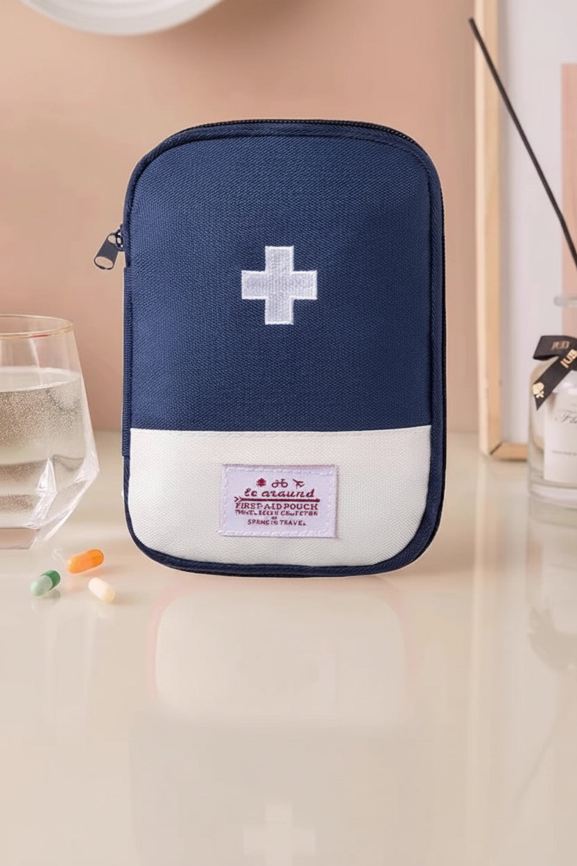 Navy blue first aid kit with a white cross on a beige background