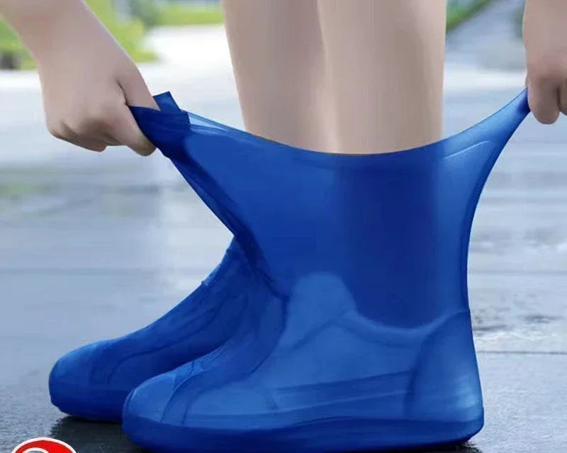Blue rain boot covers being worn on a wet pavement