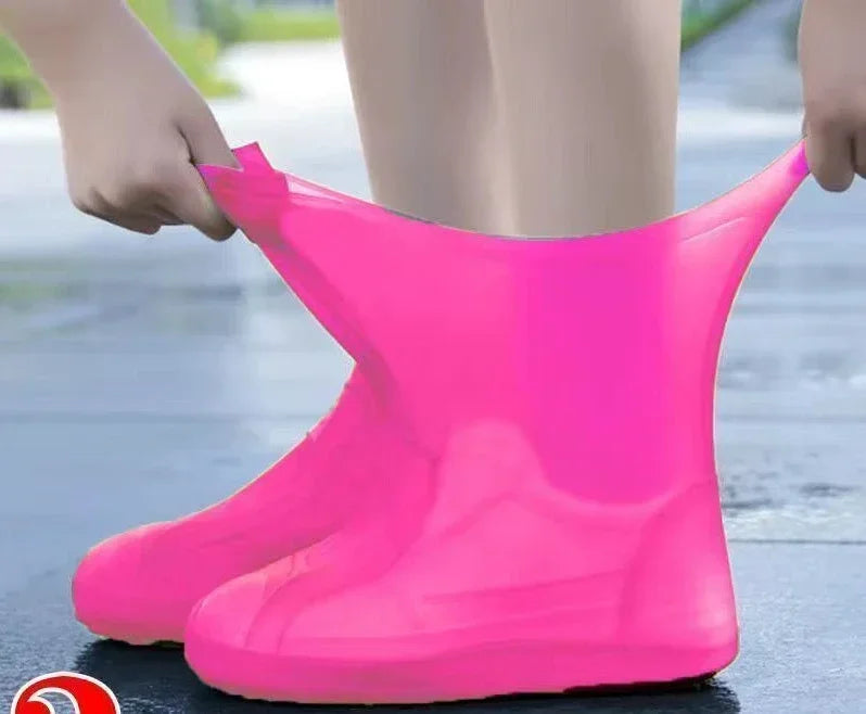 Person wearing bright pink rain boots on a wet pavement.