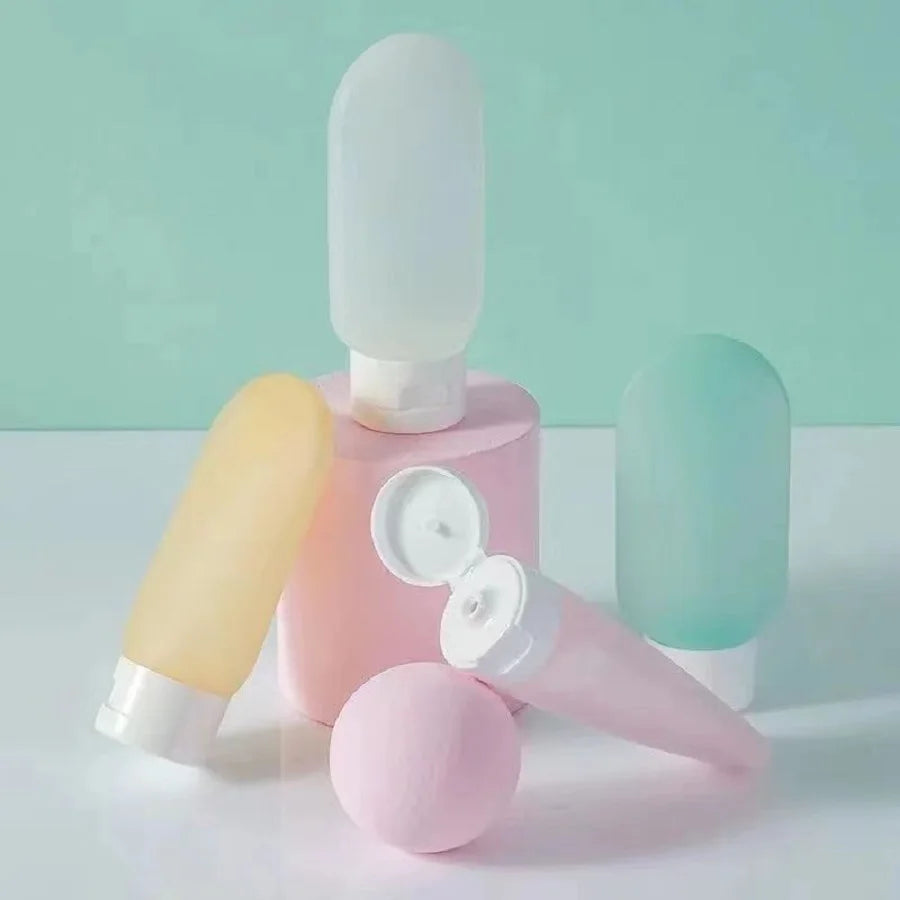 Set of pastel-colored skincare bottles on a light green background