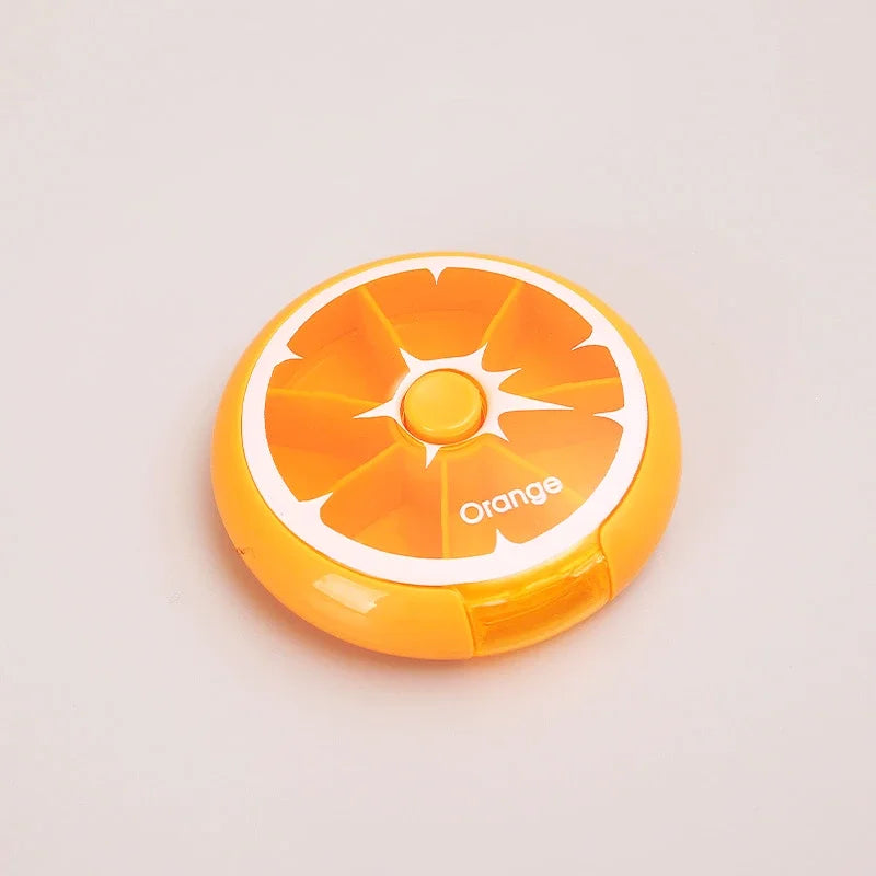 An orange-shaped compact case with a citrus slice design and the word 'Orange' printed on the front, photographed on a plain light background.