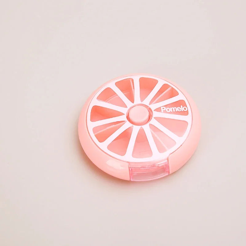 A pink pomelo-shaped cosmetic compact with a segmented lid design and the brand name 'Pomelo' printed on the top, set against a plain light beige background.