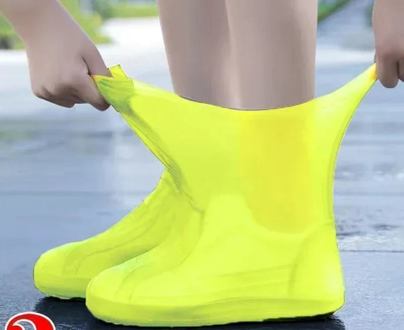 Person wearing bright yellow rain boots on a wet pavement