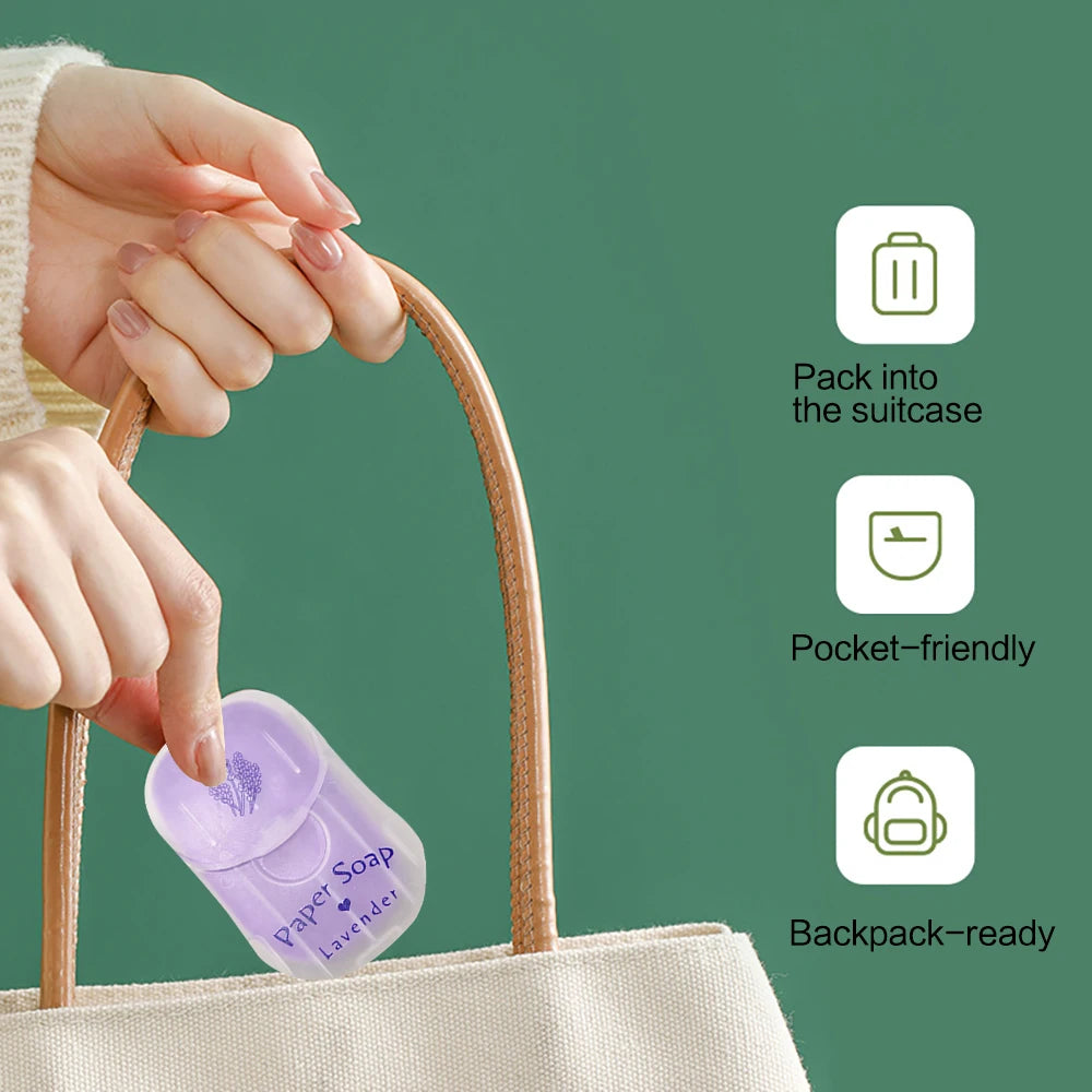 Hand holding a small lavender soap bar with packaging, placed into a beige tote bag against a green background.