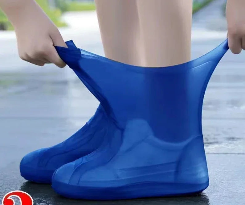 Blue rain boot being worn on a wet pavement