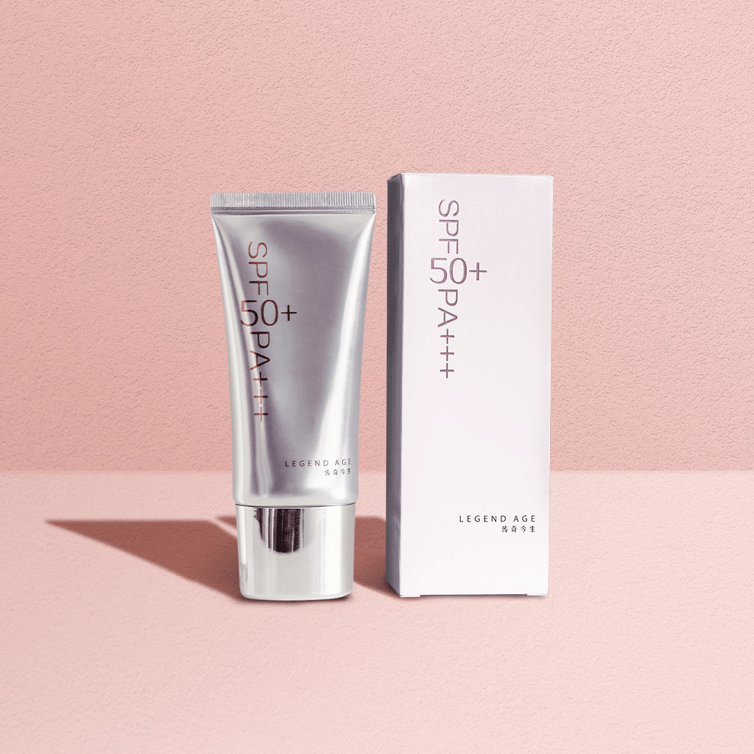 Silver sunscreen tube and packaging on a pink background